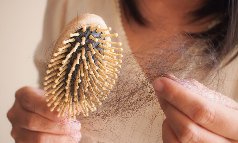 Mulher puxa cabelo preso em escova